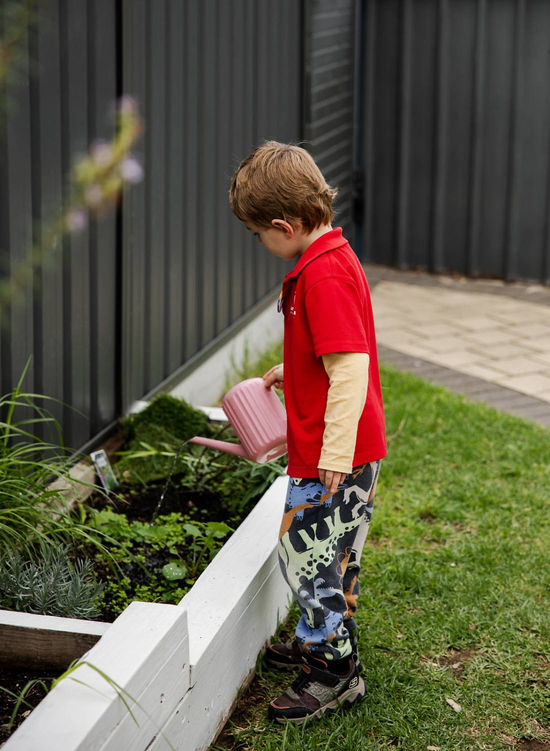 Child watering the garden outdoors
